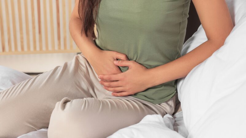 Young,Woman,Suffering,From,Cystitis,On,Bed,Indoors,,Closeup