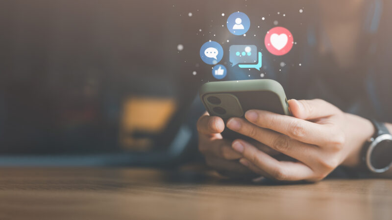 Social media and digital online concept, woman using smart phone on sofa at home. The concept of living on vacation and playing social media.