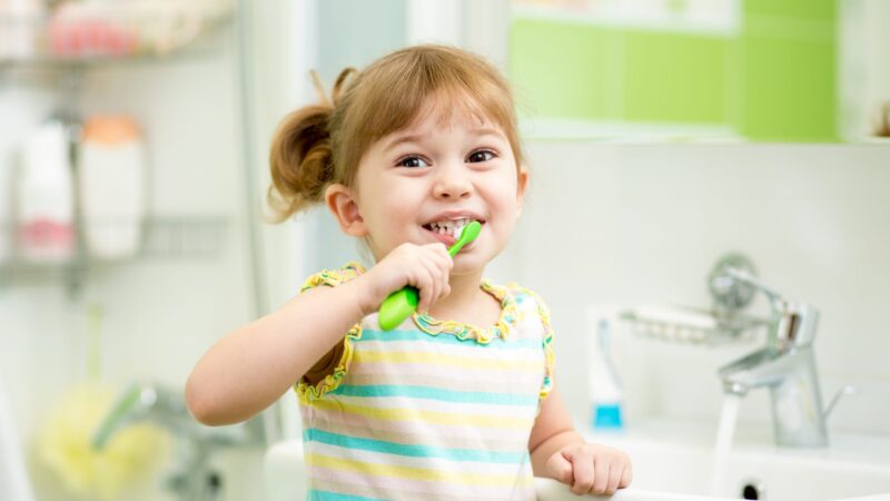 Young girl brushing teeth in bathroom