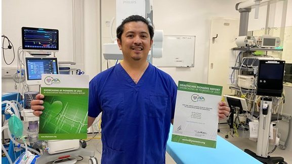Rhoel Peralta, Catheter Lab Associate Practitioner holding up award certificate